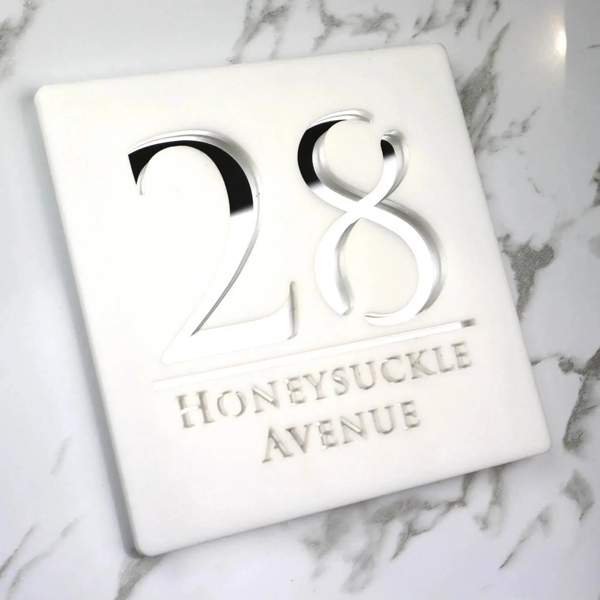 Custom square acrylic house number sign with raised numbers and street name on white marble background