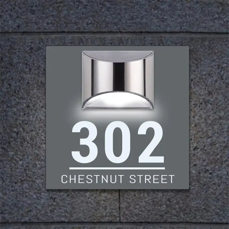 Square solar-powered acrylic house sign with custom laser-etched address and modern stainless steel light fixture